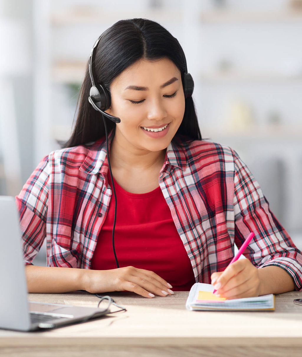 asian-female-in-headset-taking-notes-while-study-w-2021-10-11-17-43-39-utc-1.jpg